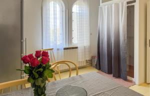 a vase of roses on a table in a dining room at Gorgeous Apartment In Högsby With Wifi in Högsby