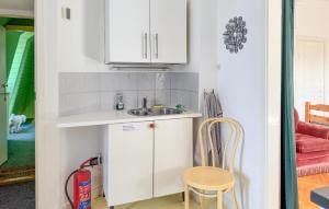 a small kitchen with a sink and a chair at Gorgeous Apartment In Högsby With Wifi in Högsby +4 photos