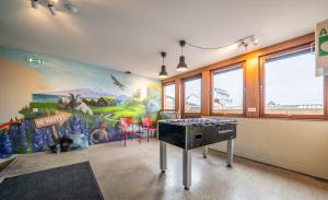 a room with a mural on the wall and a ping pong table at Loft - HI Eco Hostel in Reykjavík