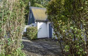 a white building with a door in the middle of trees at 3 Bedroom Cozy Home In Hammenhög in Västanbäck +14 photos