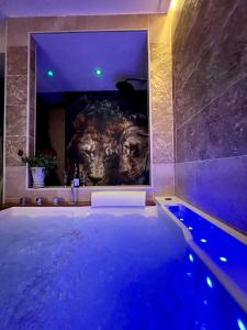 a bathroom with a swimming pool and a painting of a gorilla at Suite KalypsÔ, romantisme, balnéo et sauna privé in Quimperlé