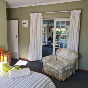une chambre avec un lit, une chaise et une table dans l'établissement Jaco and Liz's sea get away, à Hermanus