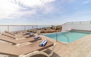 a pool on the roof of a building with chairs at Cozy Home In Torrox Costa in Torrox Costa