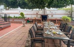 a long wooden table with chairs and plates on it at 2 Bedroom Beautiful Home In Benalmadena in Benalmadena Costa