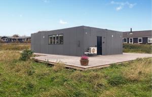a small gray building on a wooden platform in a field at 3 Bedroom Beautiful Home In Hurup Thy in Doverodde