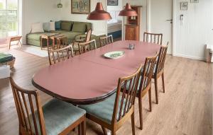 Doverodde3 Bedroom Beautiful Home In Hurup Thy的用餐室配有粉红色的桌子和椅子