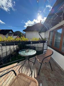 a patio with a table and chairs on a balcony at Casa Luțea in Moieciu de Jos
