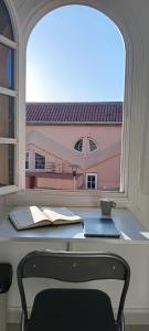 Una ventana con una mesa con un libro y una taza. en Weisshorn Bungalow 40, en Maspalomas