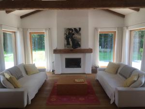 een woonkamer met 2 witte banken en een open haard bij Achberghütte in Unken