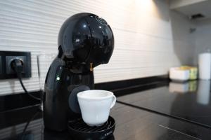 Ein Roboter macht auf einer Theke eine Tasse Kaffee in der Unterkunft Encanto en Iznájar con terraza y vistas a la montaña in Iznájar