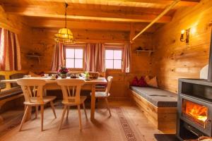 a dining room with a table and a fireplace at Berghütte Kelchsau in Kelchsau