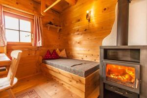 a bedroom with a fireplace in a log cabin at Berghütte Kelchsau in Kelchsau