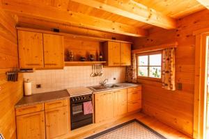 a kitchen with wooden cabinets and a sink in a cabin at Berghütte Kelchsau in Kelchsau