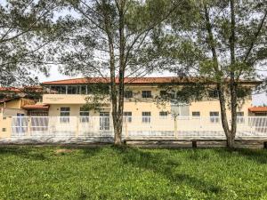 イタニャエンにあるPousada dos Ventos Itanhaémの前に木々がある大きな白い建物