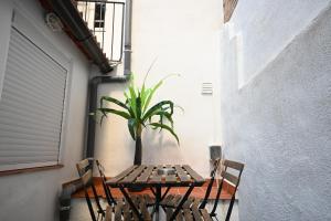 a table with two chairs and a potted plant at Homenfun Barcelona Camp Nou in Hospitalet de Llobregat