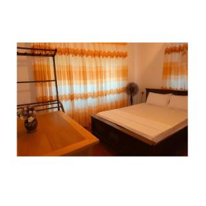 - une chambre avec 2 lits et une table avec un ventilateur dans l'établissement Aqua Bliss Resort & Villa Bentota, à Bentota