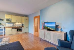 a living room with a flat screen tv on a cabinet at Fewo Melli in Zempin