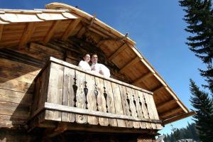 two men standing on the balcony of a tree house at Alpine-Lodges Matthias in Hintersauerwald