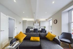a living room with a couch with yellow pillows at Aurora House 2B Warrenpoint in Newry