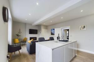 a kitchen and living room with a counter and chairs at Aurora House 2B Warrenpoint in Newry +4 photos
