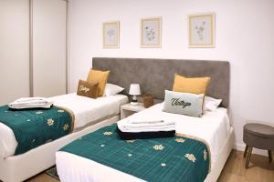 two beds in a room with a green blanket on them at InSide Furnas in Furnas