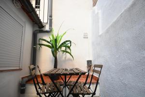a table and chairs with a potted plant on a patio at Homenfun Barcelona Camp Nou in Hospitalet de Llobregat