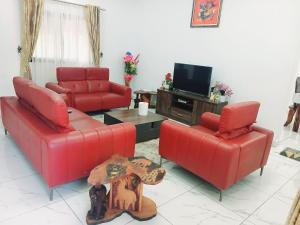 a living room with two red couches and a tv at Résidence Meublée Yaya Azur in Azuretti
