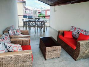 a balcony with wicker furniture and a table and chairs at Résidence Meublée Yaya Azur in Azuretti