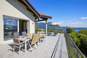 a patio with chairs and tables and an umbrella at Villa Spa Nipotine in Cissano