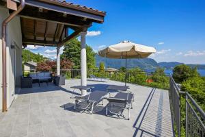 a patio with a table and chairs and an umbrella at Villa Spa Nipotine in Cissano