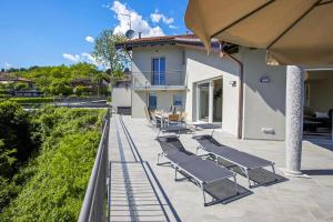 a group of lounge chairs on a patio at Villa Spa Nipotine in Cissano +26 photos