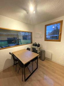 a dining room with a table and chairs and a window at Gîte au calme en pleine nature in Signy-le-Petit
