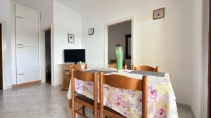 a dining room with a table with chairs and a television at VILLAMAR beachfront apartments with FREE private parking in Rabac
