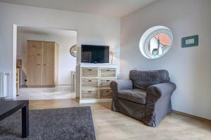 sala de estar con silla y TV de pantalla plana en Fewo Bruno, en Ahlbeck