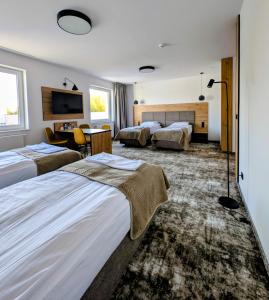 une chambre d'hôtel avec deux lits et une télévision dans l'établissement Hotel Eden, à Rzgów