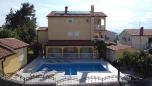 a house with a swimming pool in front of it at Apartments Šerbečić in Malinska
