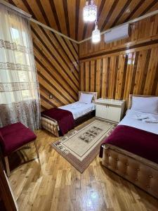 a room with two beds in a wooden cabin at Sheki Modern Guest Home in Sheki