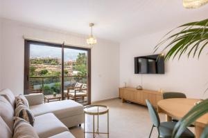 a living room with a couch and a tv and a table at EK Renting in Adeje