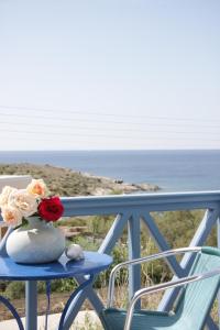 een vaas met bloemen op een tafel op een balkon bij Manos Apartments in Megas Gialos - Nites