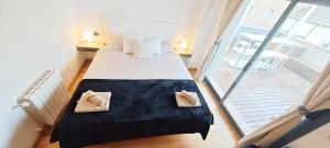 a bedroom with a large bed with two pillows at Great apartment with a pool on the beach in Barcelona in Badalona +39 photos