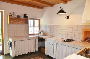 a kitchen with white tiled counters and a sink at Kohlstatt Hütte in Verano