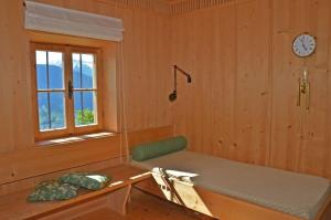 a room with a bench and a clock on the wall at Kohlstatt Hütte in Verano