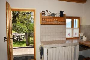 a kitchen with a counter and a view of a yard at Kohlstatt Hütte in Verano