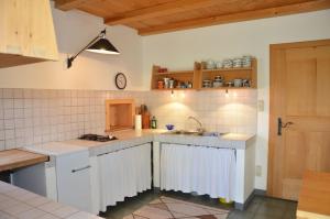 a kitchen with white cabinets and a sink at Kohlstatt Hütte in Verano