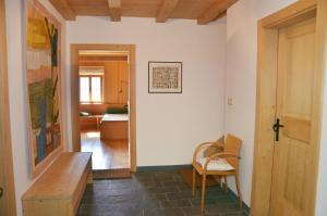 a room with a hallway with a table and a chair at Kohlstatt Hütte in Verano +10 photos