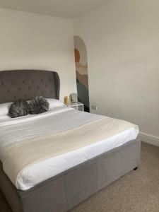 a bedroom with a large bed with white sheets at The Spacious Stay Stratford in London