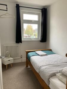 a bedroom with a bed and a window at The Spacious Stay Stratford in London