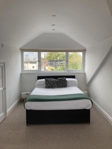 a bedroom with a bed with a large window at The Spacious Stay Stratford in London