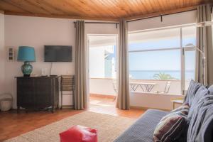 a living room with a view of the ocean at Calheta House in Luz in Luz
