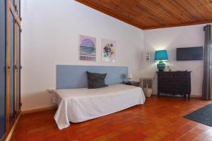 a bedroom with a bed and a table with a lamp at Calheta House in Luz in Luz
